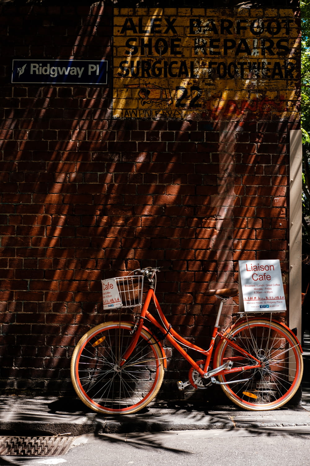 a bicycle parked next to a brick wall