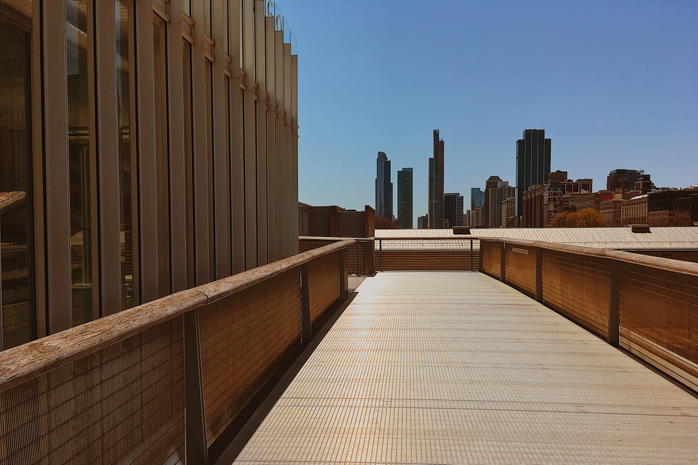 brown wooden fence near high rise buildings during daytime