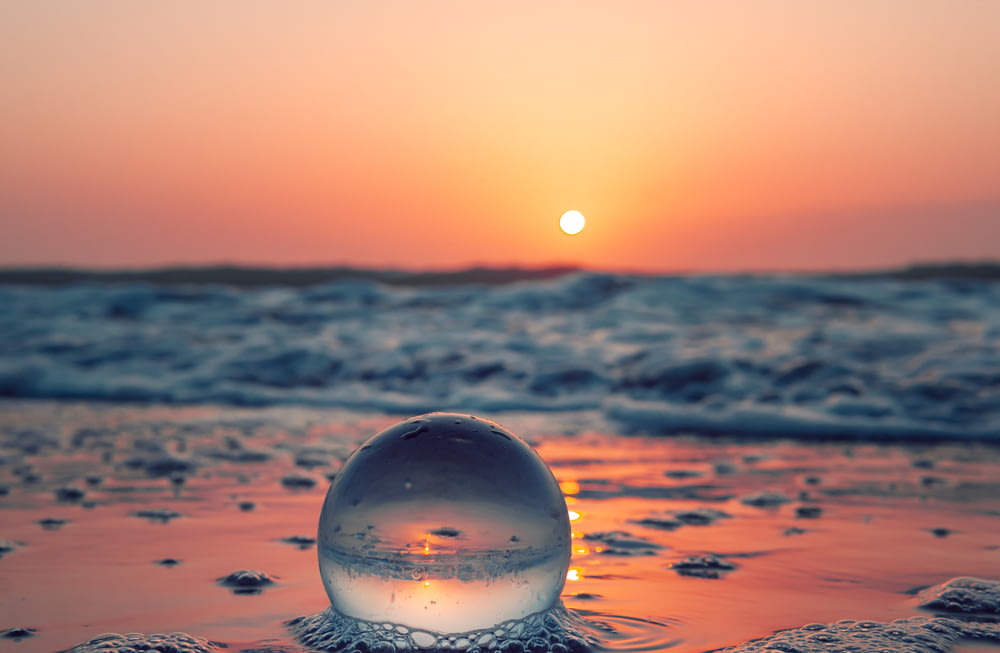 bola de vidrio transparente en el agua durante el día