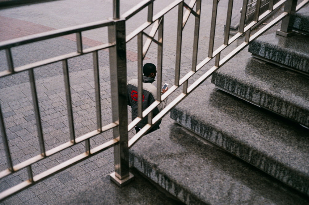 person in black hoodie standing on gray concrete staircase