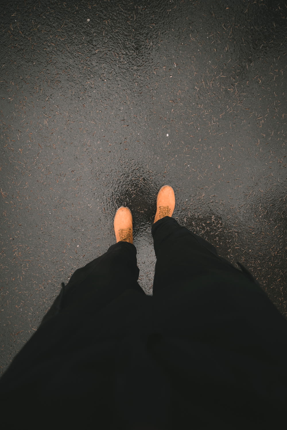 person in black pants and brown shoes