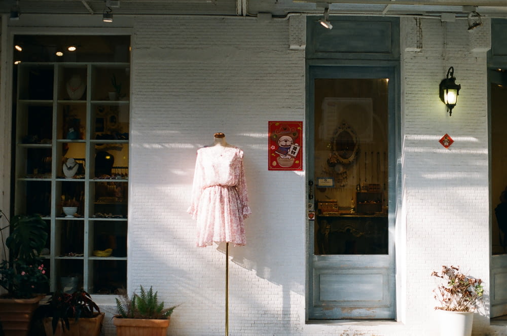 woman in white long sleeve dress standing beside white wooden door
