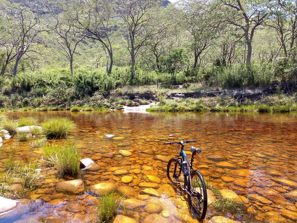 black mountain bike on river during daytime