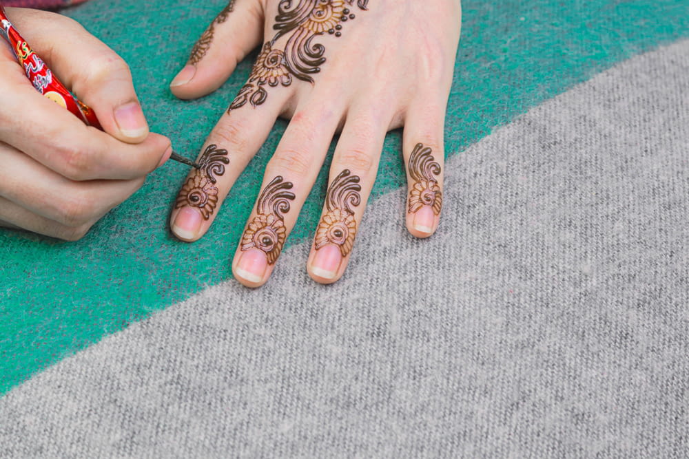 Persona con tatuaggio floreale in bianco e nero sulla mano sinistra