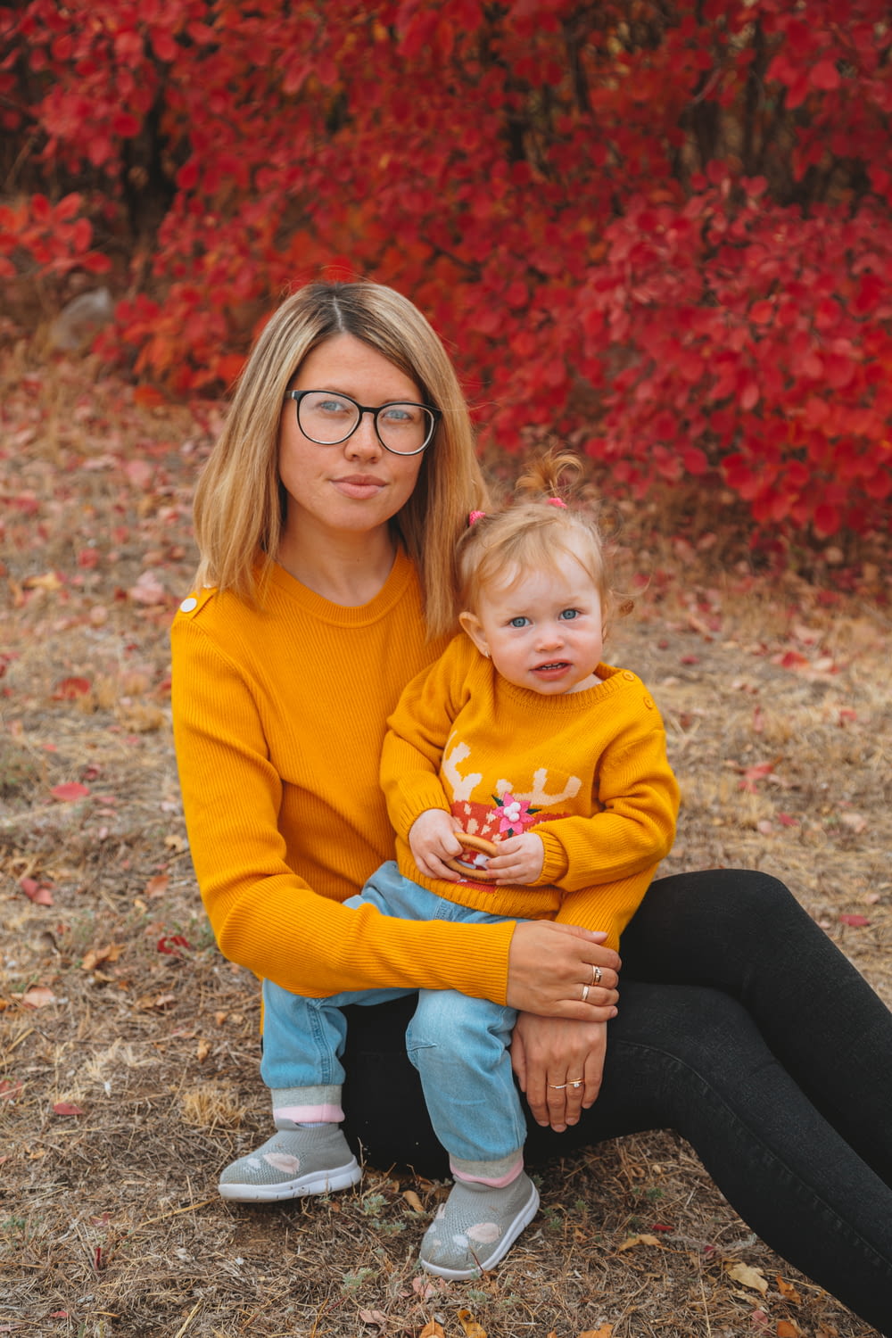 woman in yellow sweater carrying baby in yellow sweater