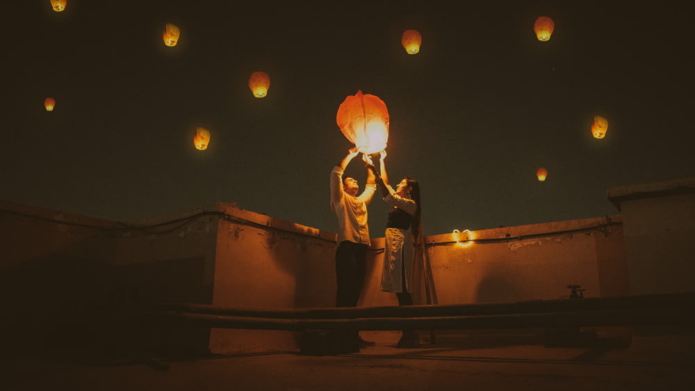 Homme et femme debout sur le toit pendant la nuit