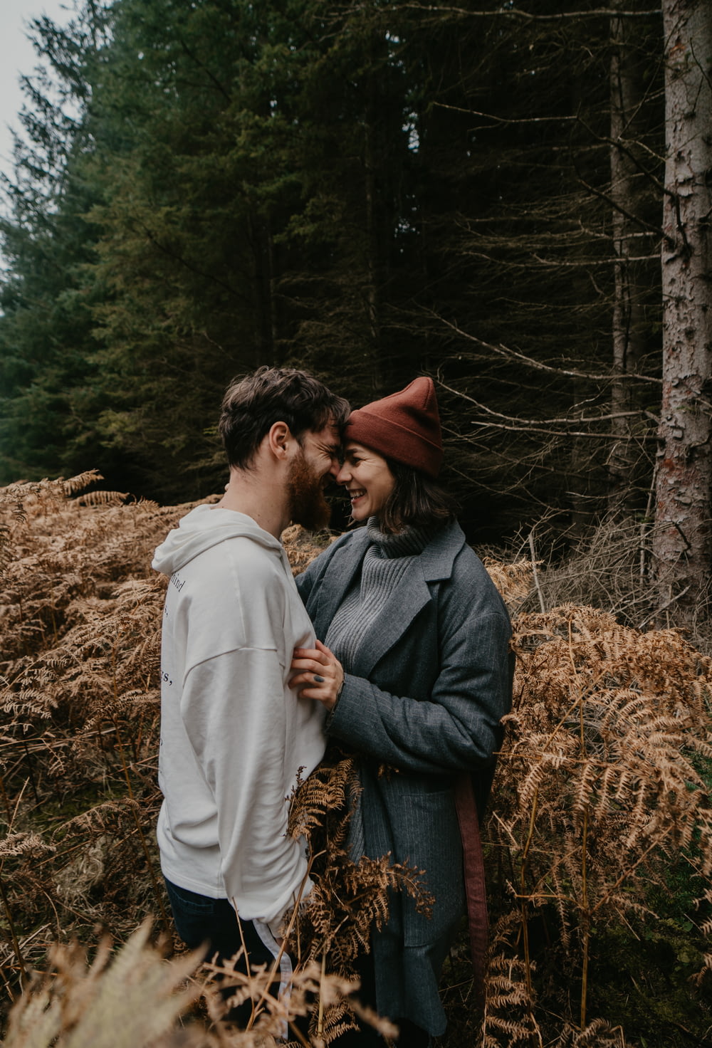 homme et femme s’embrassant sur le champ d’herbe brune pendant la journée