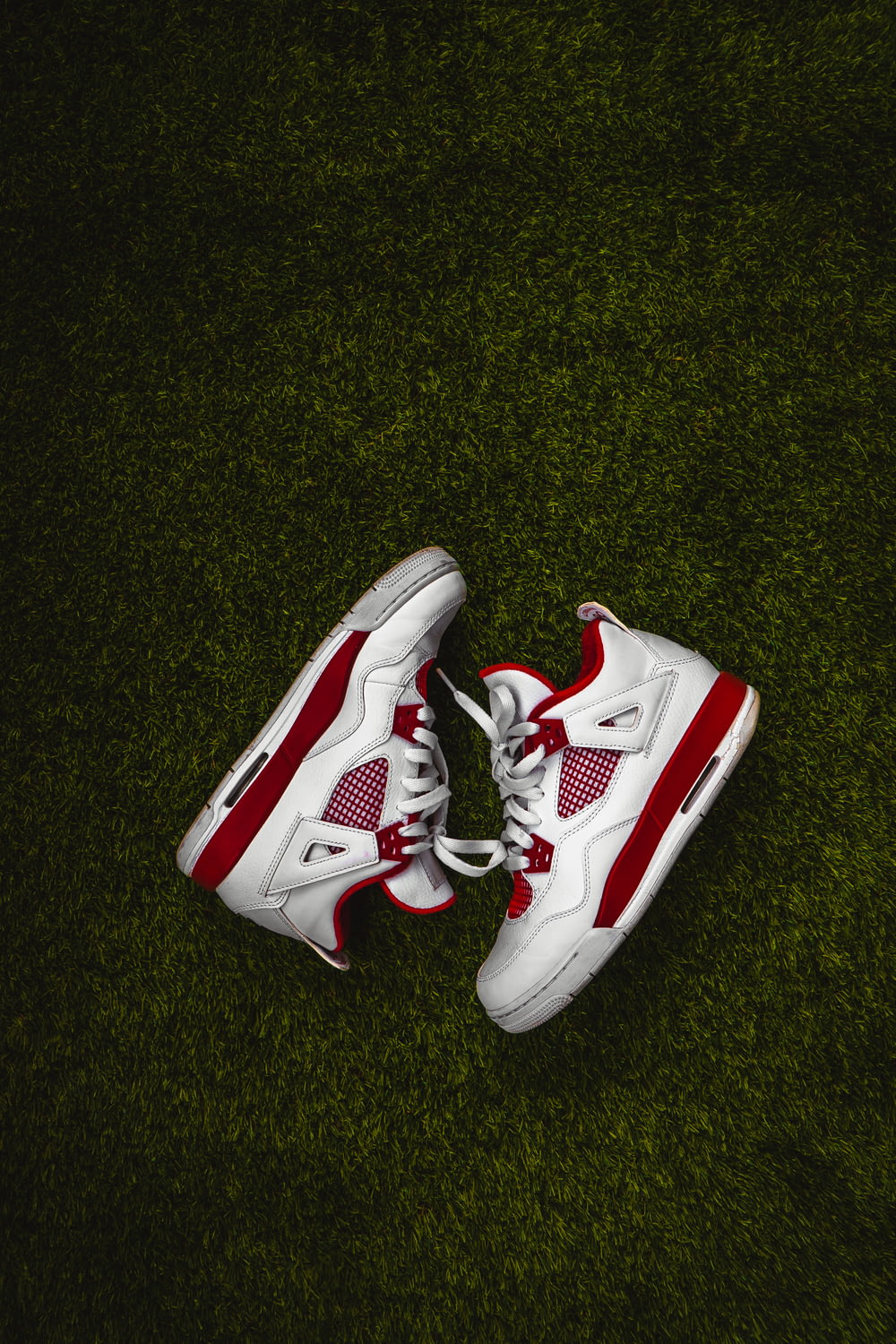 white and red nike basketball shoes on green grass