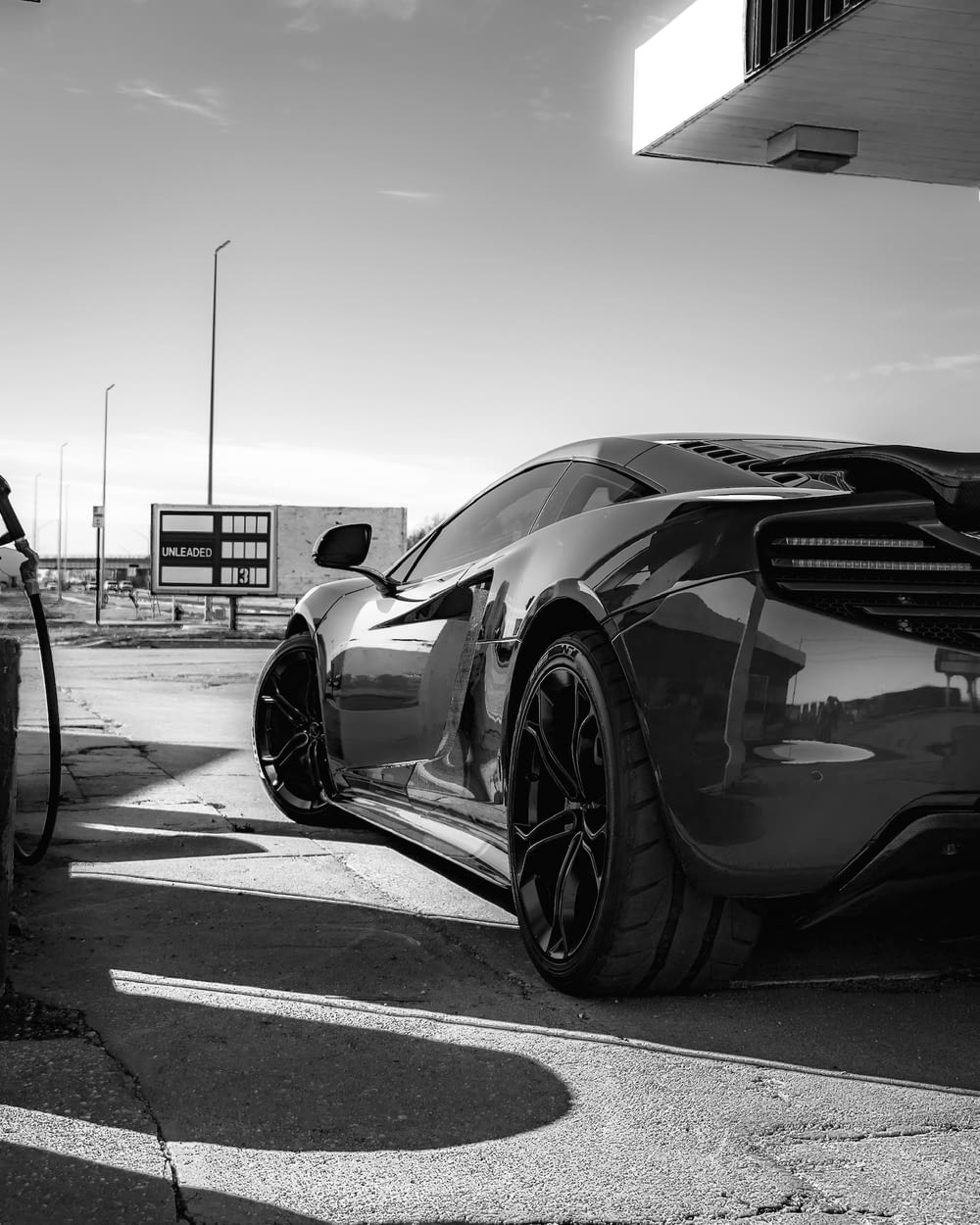 grayscale photo of sports car on road