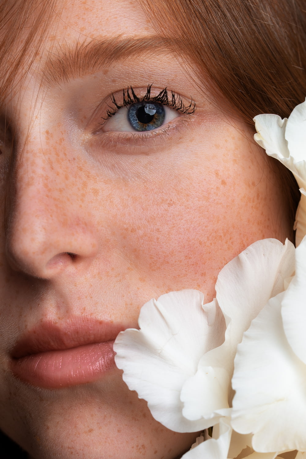mujer con flor blanca en la oreja