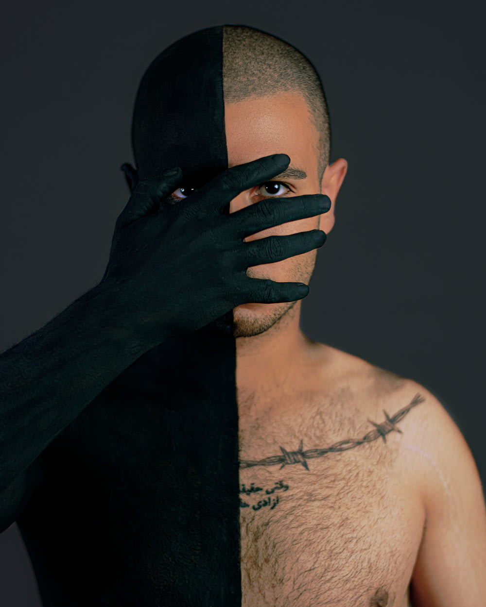 topless man with black tattoo on his face