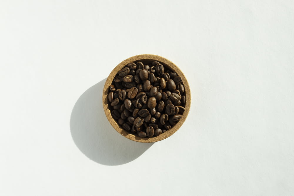 a small wooden bowl filled with coffee beans