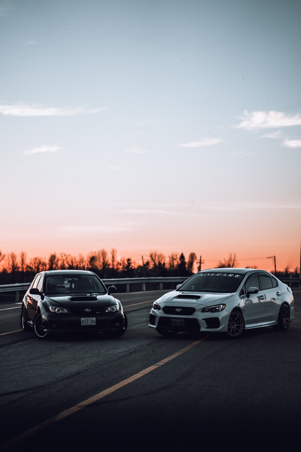 white and black cars on road during sunset