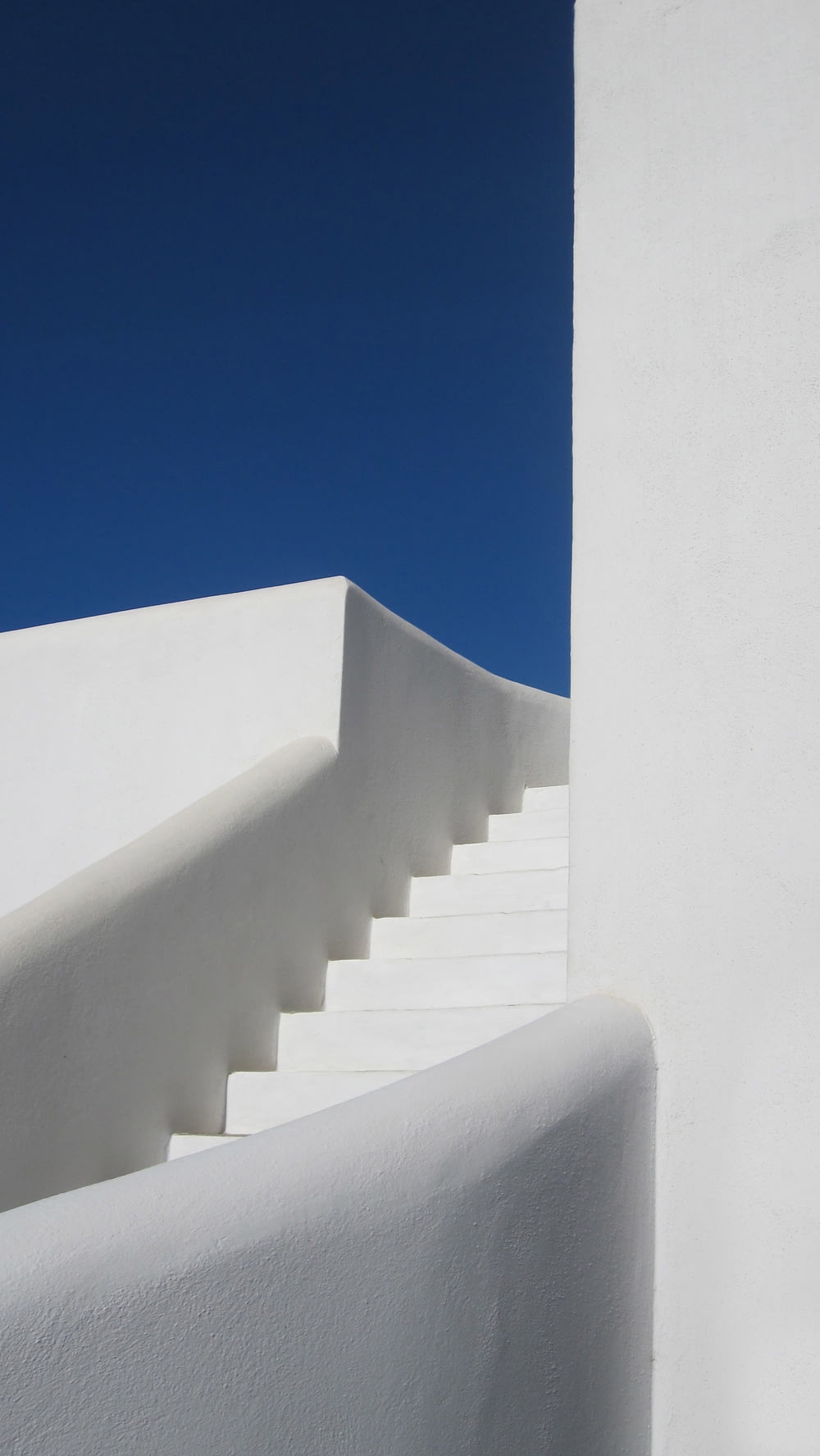escada de concreto branco sob o céu azul durante o dia