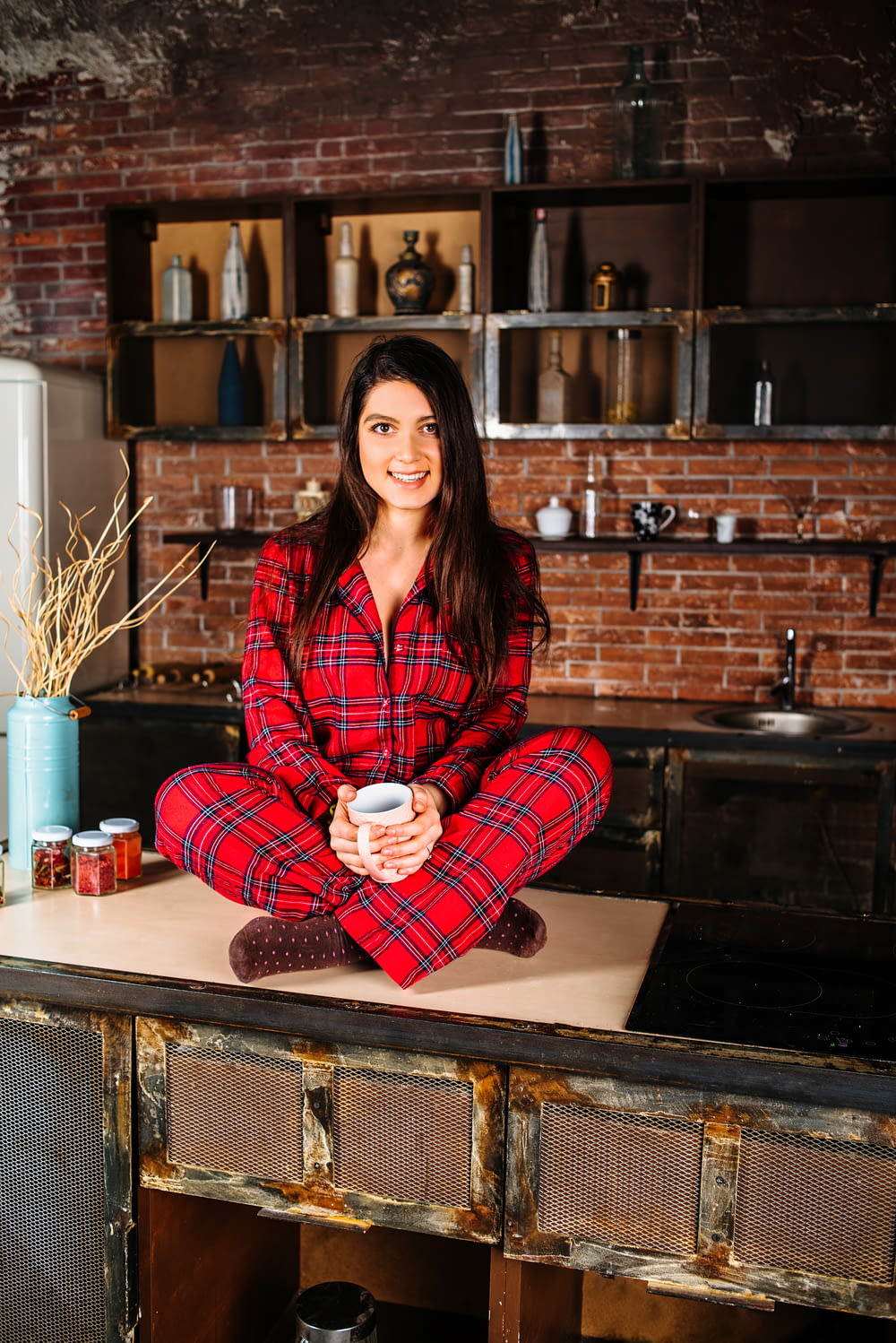 woman in red and white plaid coat sitting on brown wooden table