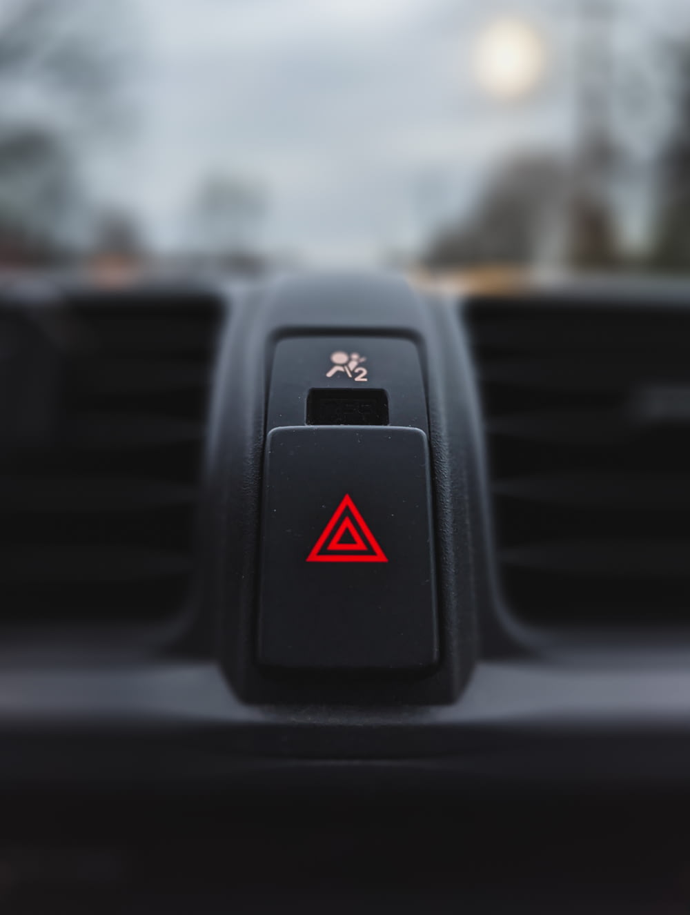 um close up da saída de ar de um carro com um triângulo vermelho sobre ele