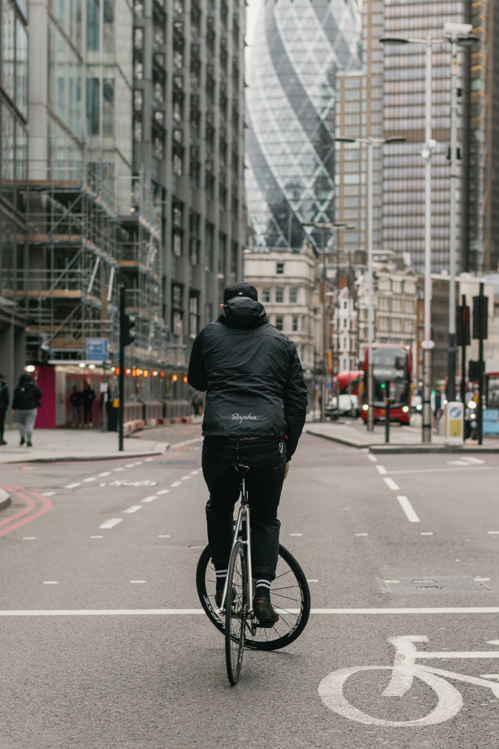 uomo in giacca di pelle nera che va in bicicletta su strada durante il giorno