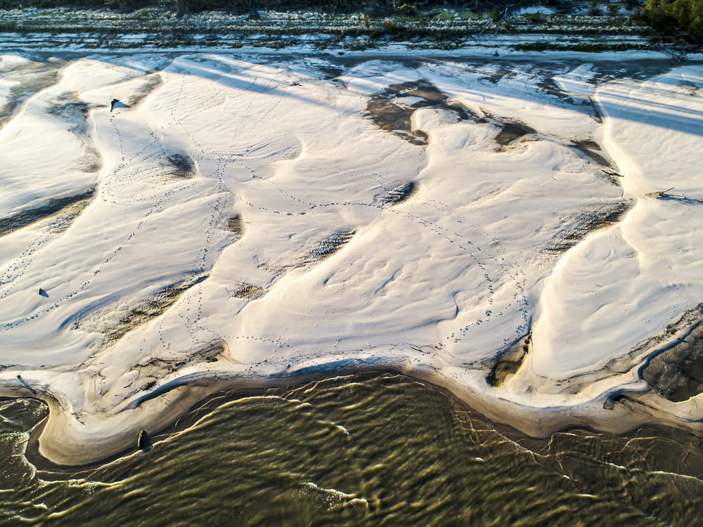 sable brun près d’un plan d’eau pendant la journée