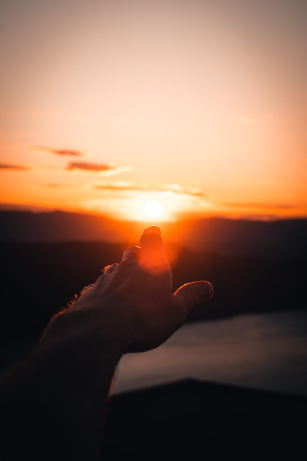 person holding sun during sunset