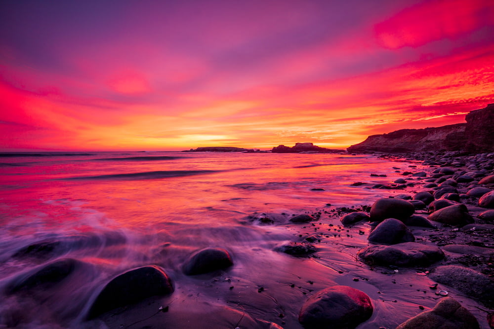 rocky shore during sunset with red sky