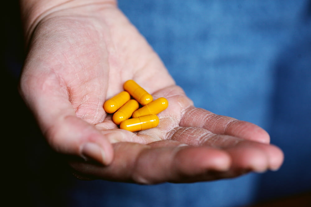 pílula de medicação amarela na mão das pessoas