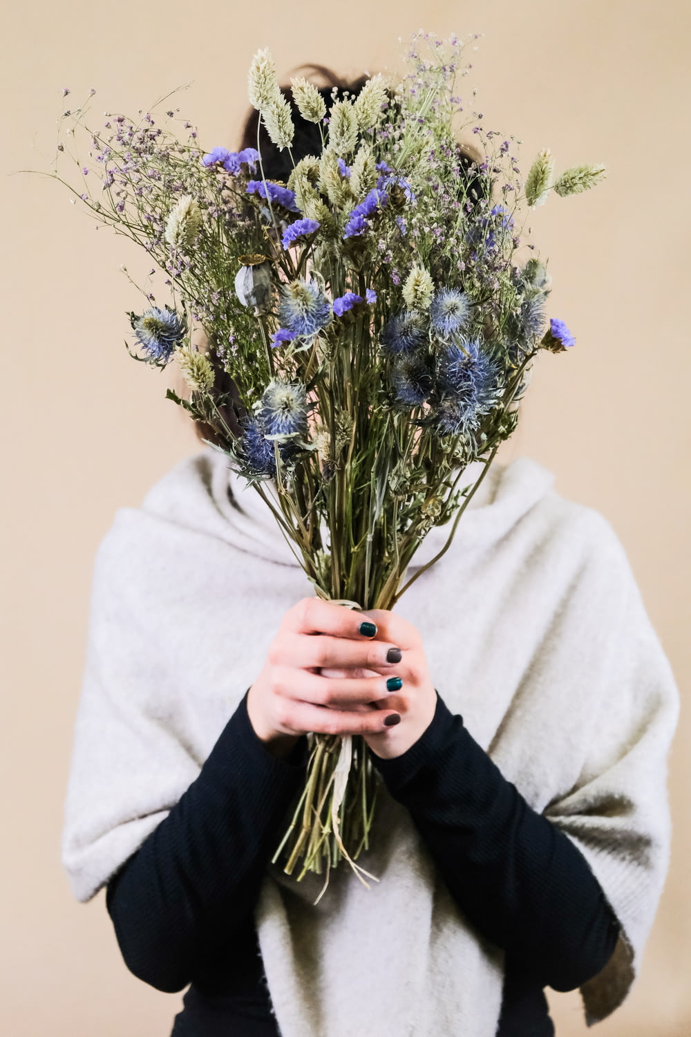 person holding purple flower bouquet