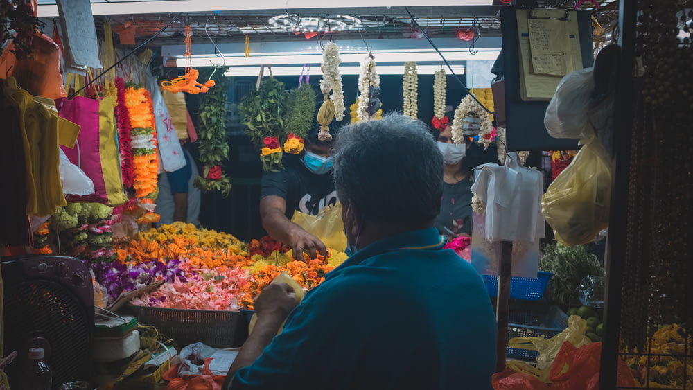 man in blue shirt standing in front of fish store