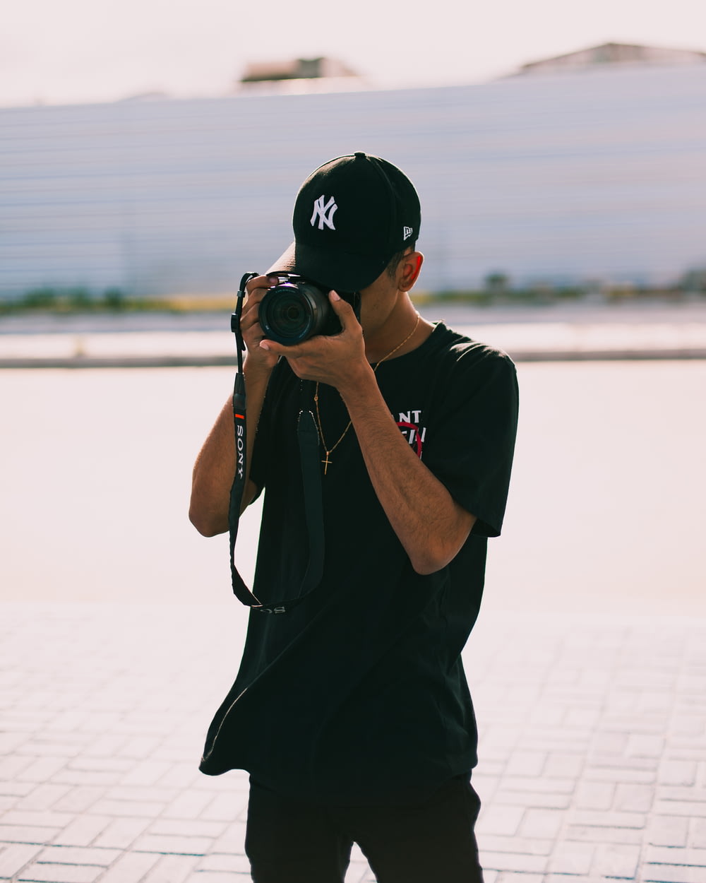 homem na camiseta preta segurando a câmera dslr preta