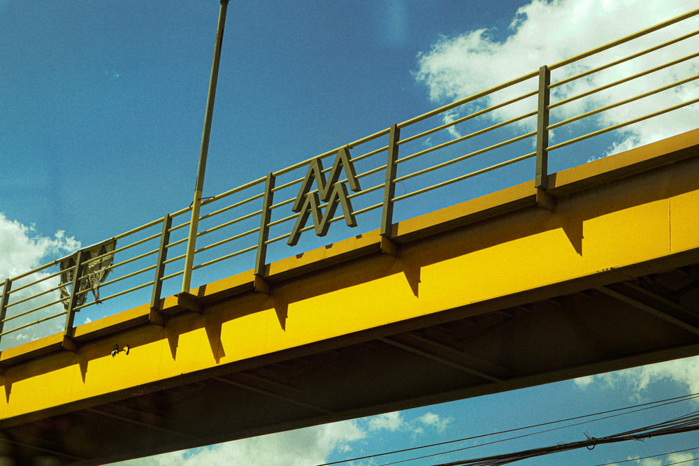 yellow metal bridge under blue sky during daytime