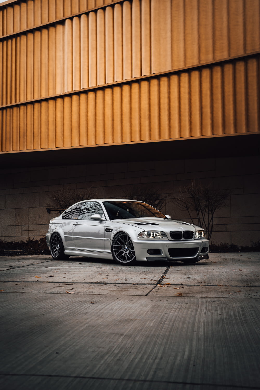 white bmw m 3 coupe parked beside orange wall