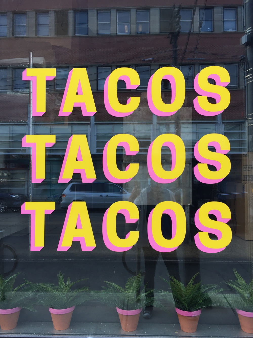 Una finestra con un cartello che dice tacos tacos