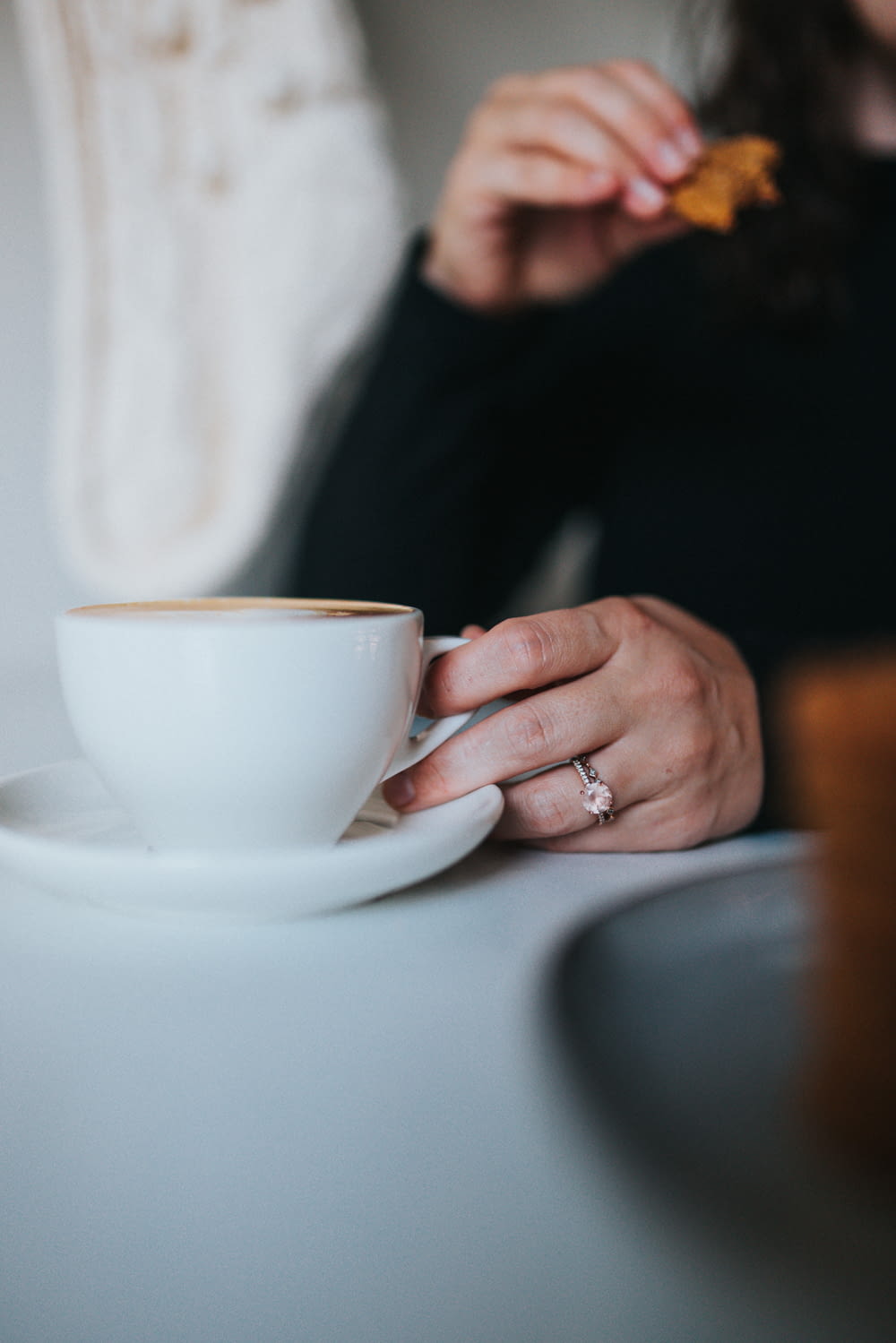 person holding white ceramic teacup