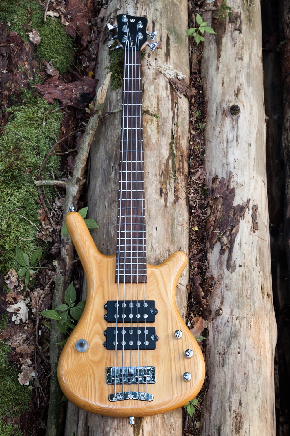 yellow electric guitar on tree trunk