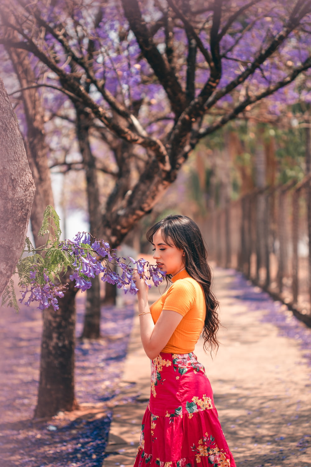 girl in red and white floral dress holding purple flowers