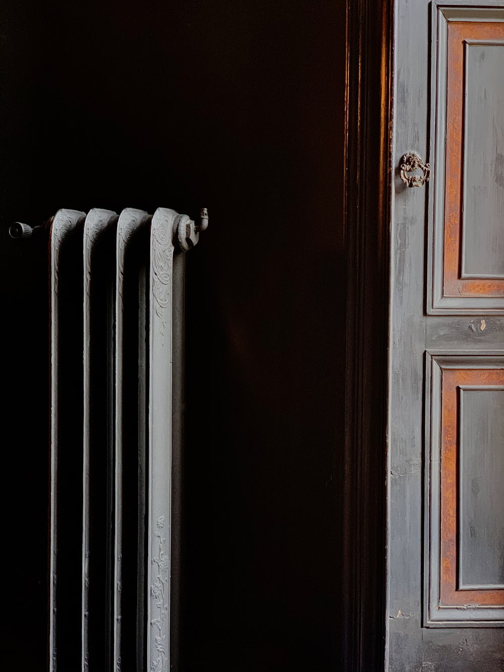 white heater radiator beside brown wooden door