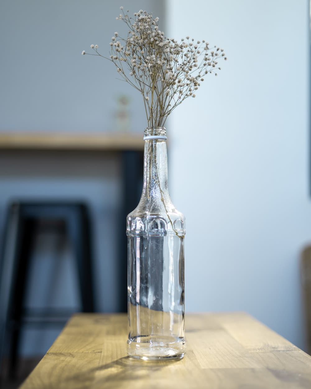 white flowers in clear glass vase on brown wooden table