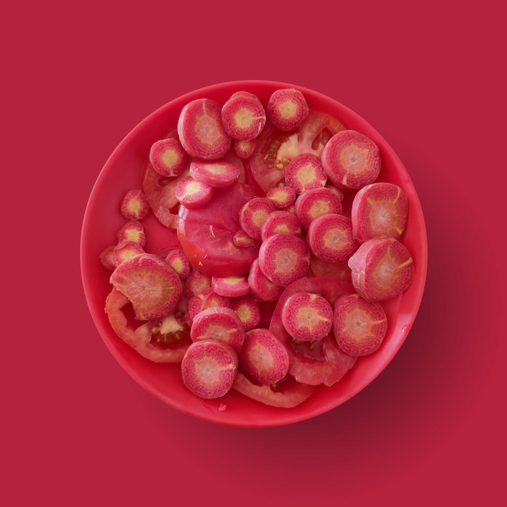 red and white round fruits on red round bowl