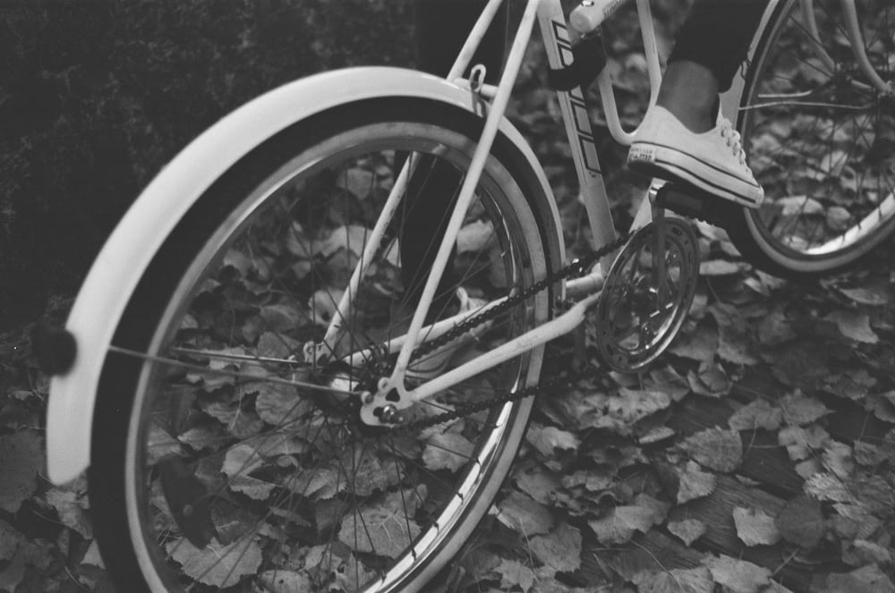 grayscale photo of person riding bicycle