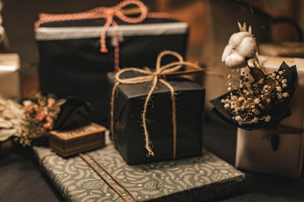 schwarz-braune Geschenkbox auf weißem und schwarzem Blumentextil