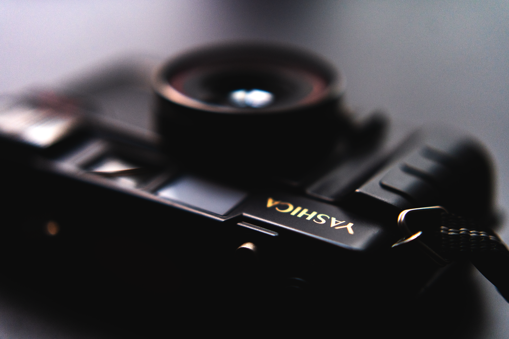 black nikon camera lens on black surface