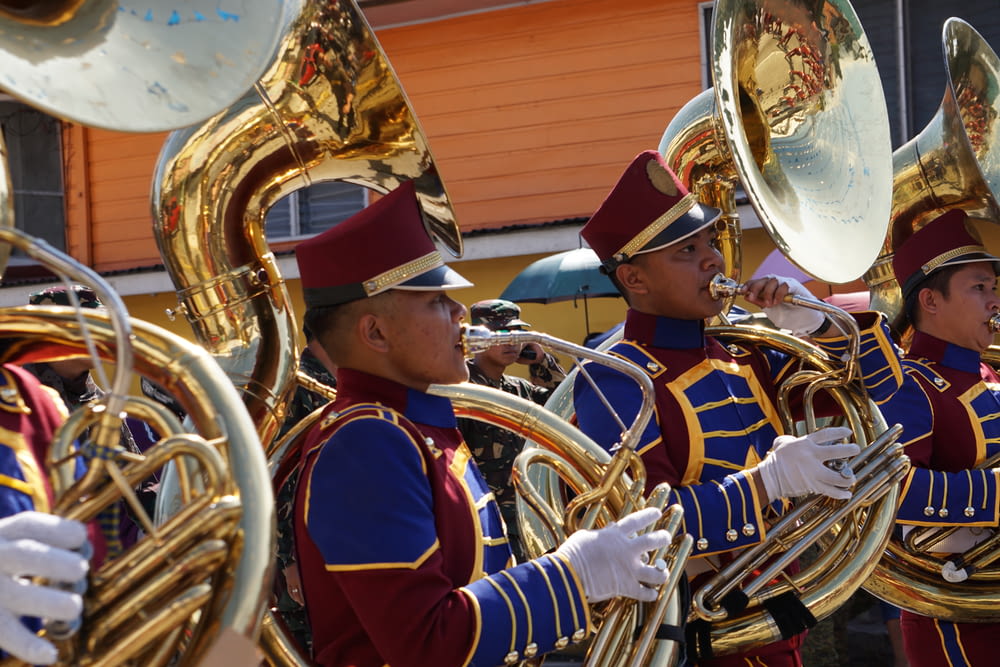 Persone in uniforme blu e rossa che suonano strumento musicale