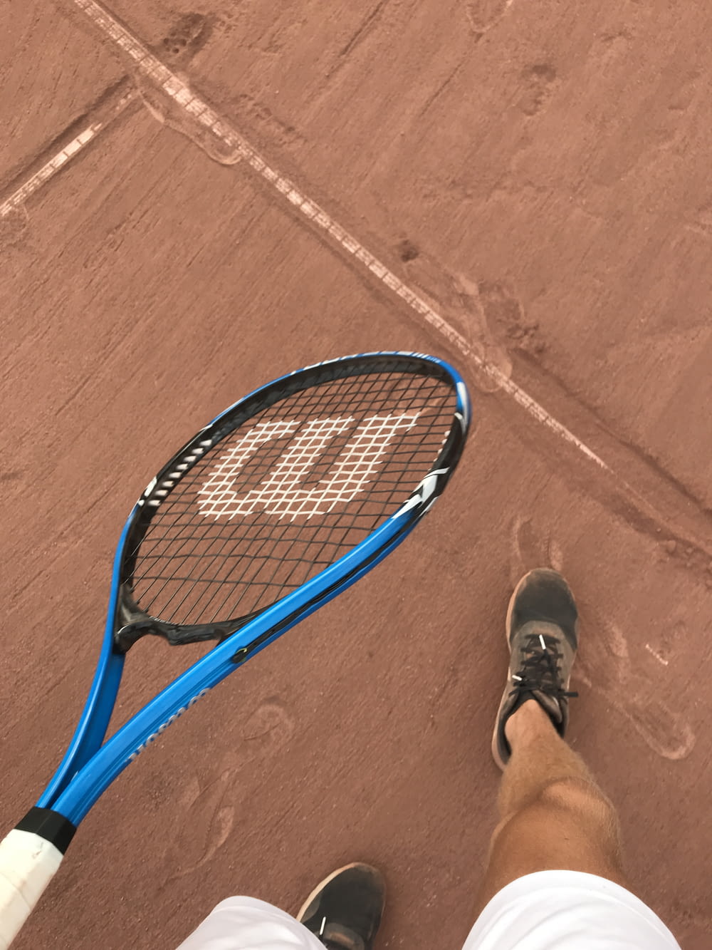 blue and black tennis racket on brown concrete floor