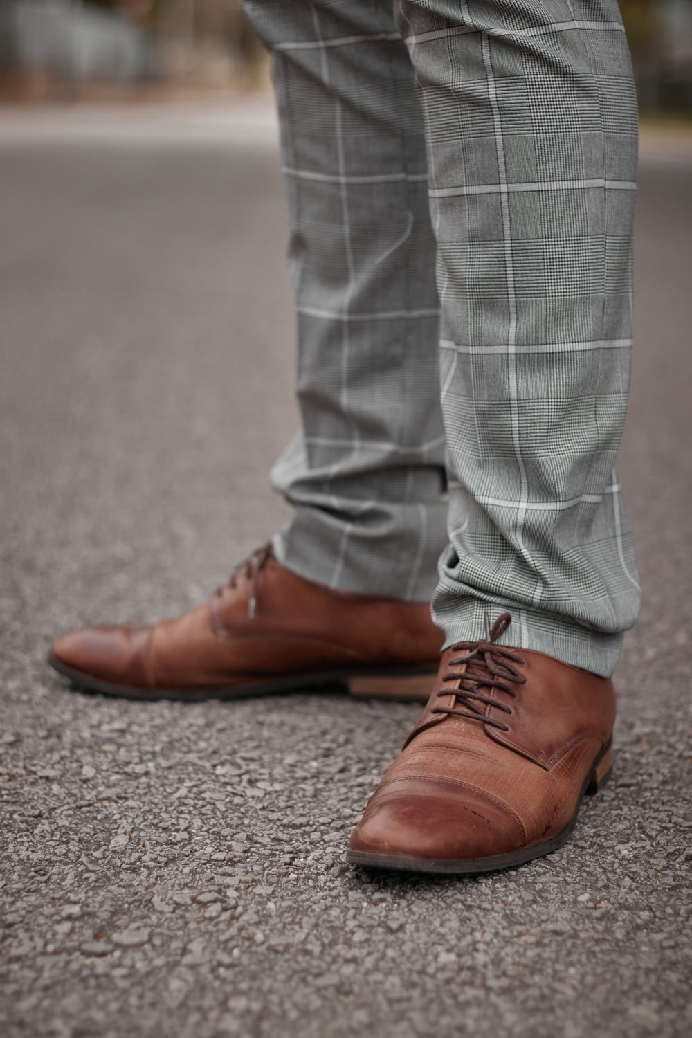 person in gray denim jeans and brown leather shoes