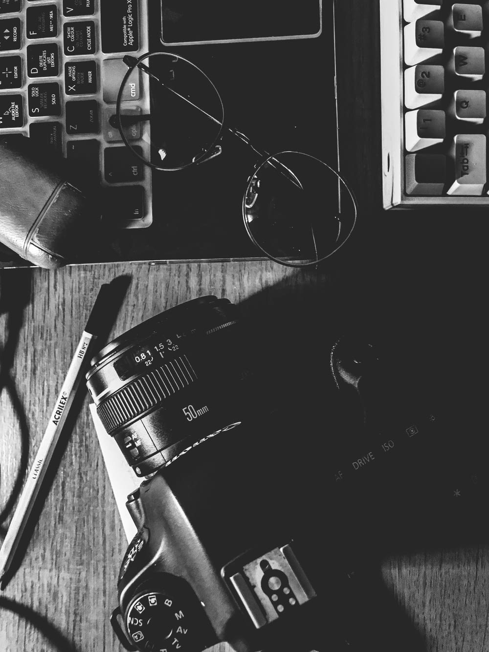Appareil photo reflex numérique Nikon noir à côté du clavier d’ordinateur noir et argenté