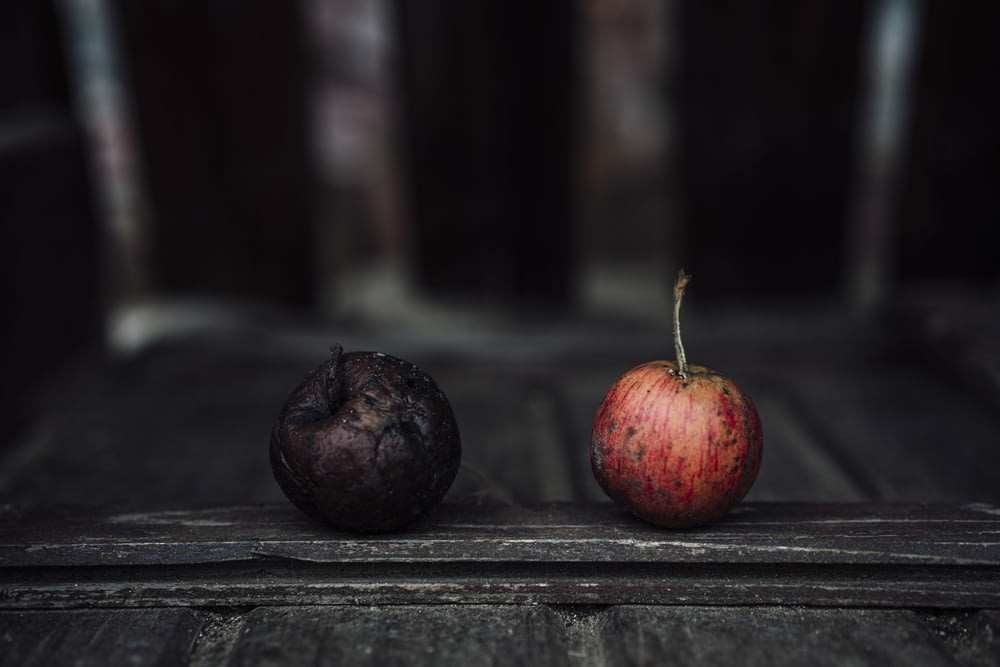 frutas redondas vermelhas e pretas na mesa de madeira preta