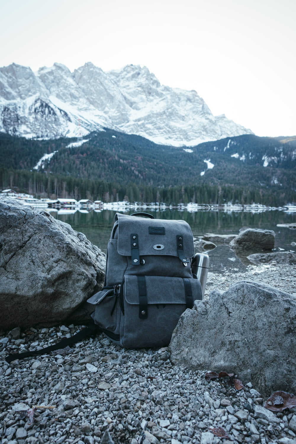 blue and gray backpack on gray rock near body of water during daytime