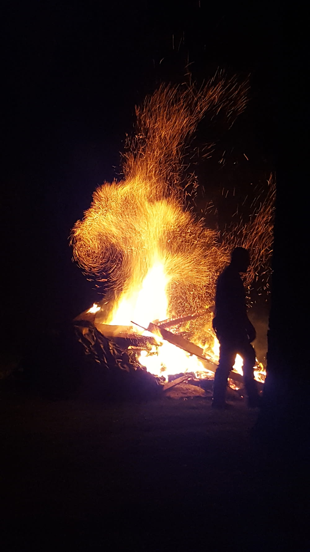 man standing near bonfire during night time