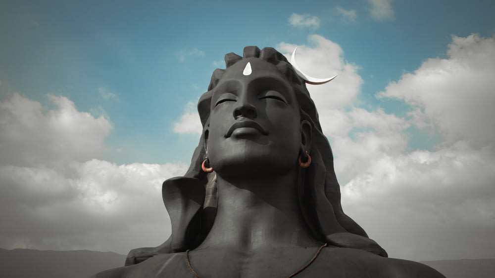 Estatua de hormigón gris bajo el cielo azul durante el día