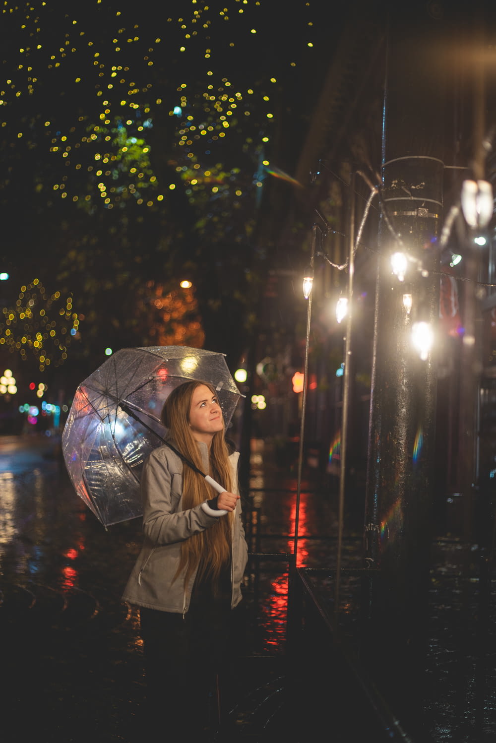 woman in brown coat holding umbrella during night time