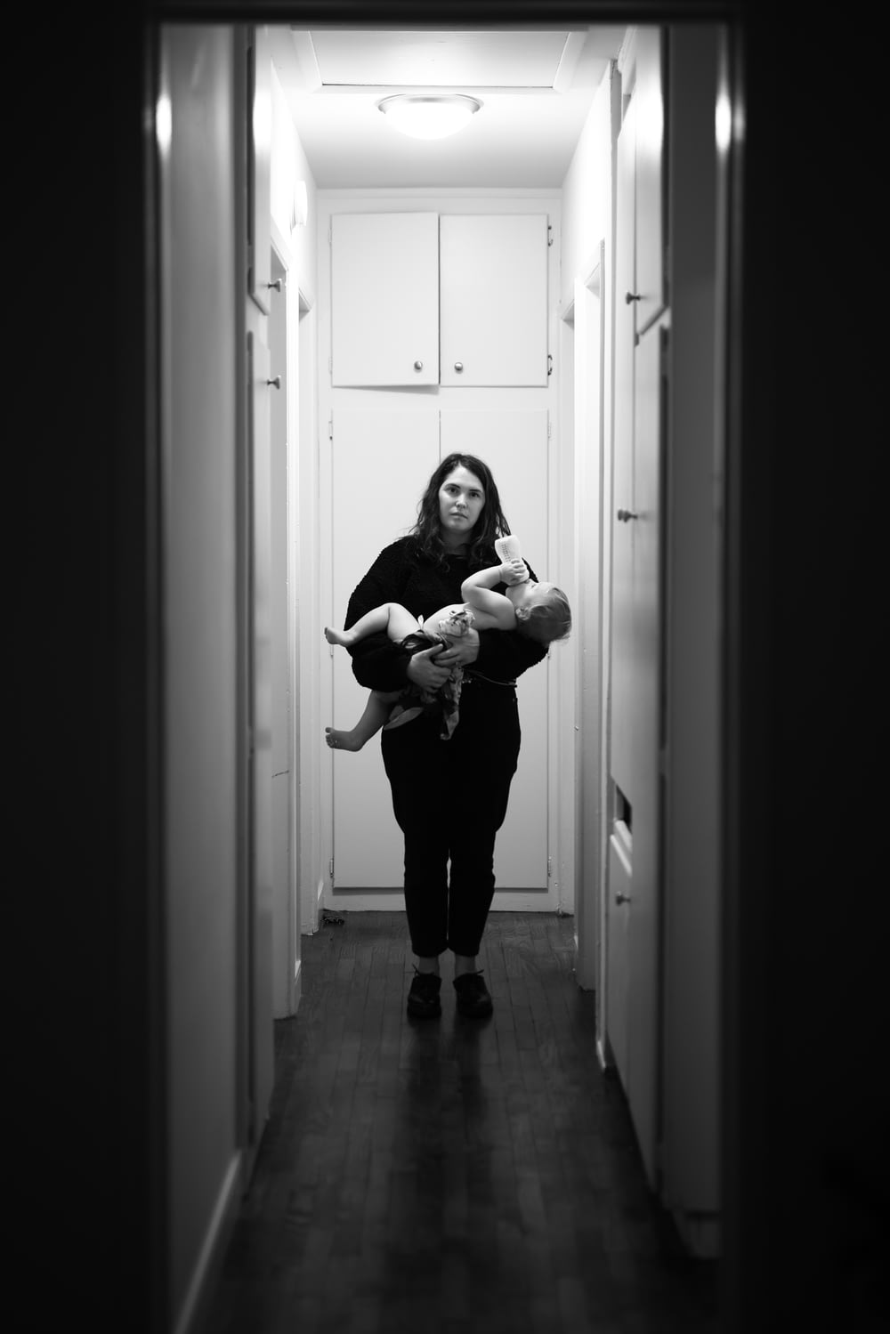 woman in black long sleeve shirt carrying baby in grayscale photography
